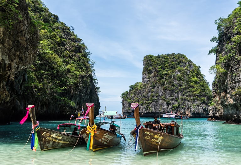 Bucht mit Longtail-Booten und Kalksteinfelsen in Südthailand